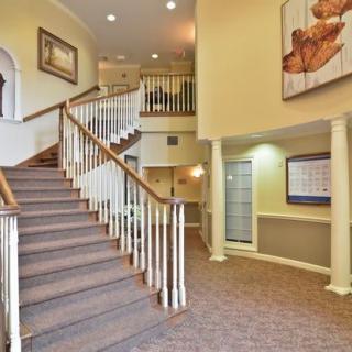 A spacious lobby with a central staircase and elegant decor.