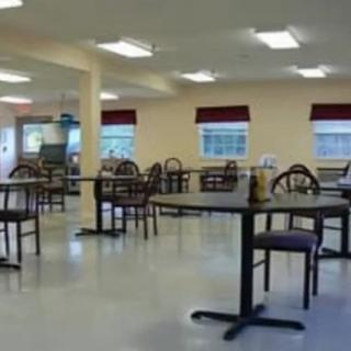 An empty cafeteria with tables and chairs neatly arranged.