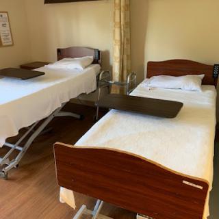 A view of a hospital room featuring two adjustable beds.