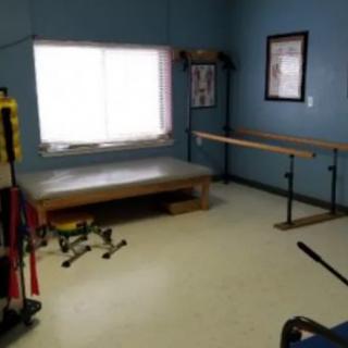 A well-equipped exercise room with various workout equipment and a large window.