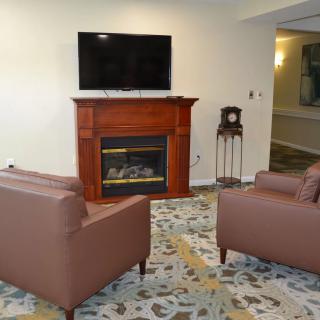 A cozy living room featuring a fireplace, television, and comfortable seating.