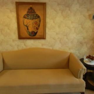 A cozy living room with a beige sofa and artwork on the wall.