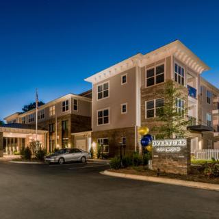 A modern hotel building illuminated at night.