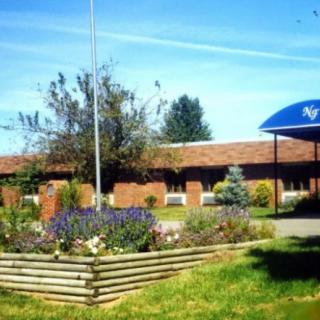 A brick building with landscaped flower beds on a sunny day.