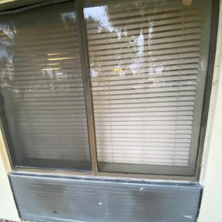 A window with closed blinds, showcasing the exterior of a building.