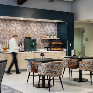 A modern caf interior featuring stylish furniture and a barista preparing beverages.