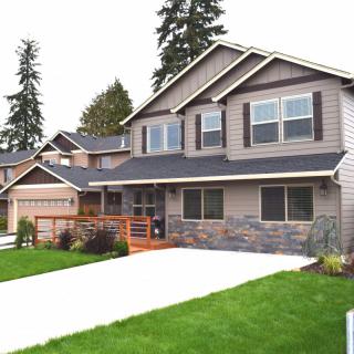 A modern suburban house with a manicured lawn and a spacious driveway.