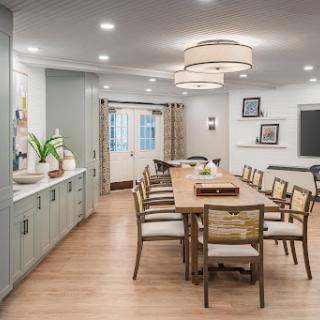 A modern dining room featuring a spacious wooden table, stylish chairs, and contemporary lighting.