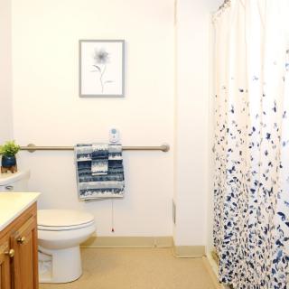 A modern and clean bathroom with a patterned shower curtain and neatly arranged towels.