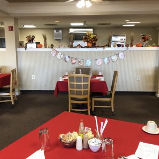 A cozy restaurant dining area with tables and chairs, featuring festive decorations.