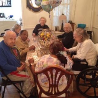 A group of elderly individuals enjoying a meal together in a cozy dining room.