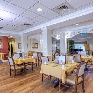A spacious and elegantly decorated dining room with neatly arranged tables and chairs.