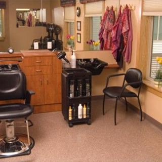 Interior of a cozy hair salon with chairs and hair-washing station.