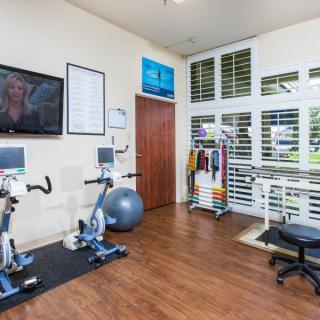 A well-equipped exercise room with stationary bikes and a television.