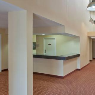 A quiet office lobby with a reception counter and hallway.