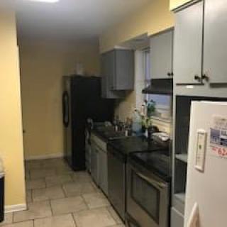 A modern kitchen with yellow walls, featuring appliances and cabinets.