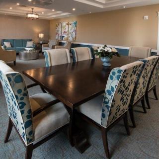 A modern dining room with a dark wooden table and upholstered chairs in a well-decorated living space.