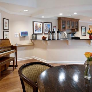 A cozy kitchen and dining area featuring a piano, wooden furniture, and stylish decor.