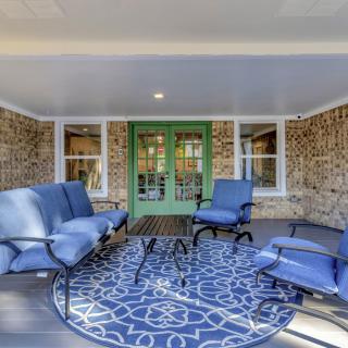 A cozy patio area with blue cushioned seating and a decorative rug.