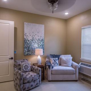 A cozy living room corner with comfortable seating and warm lighting.