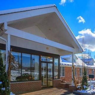 A modern building entrance with snow on the ground and a clear blue sky.