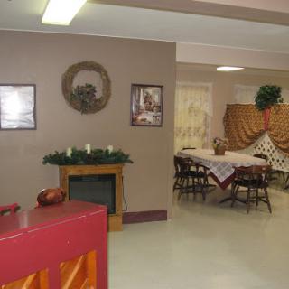 A cozy dining space featuring tables set for a gathering, complemented by warm decor and wall art.