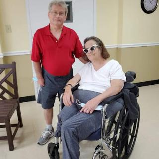 A supportive moment shared between two individuals in a care facility.