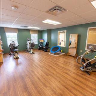 A well-equipped rehabilitation room featuring various exercise machines for therapeutic purposes.