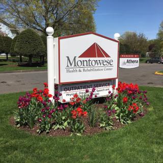 A welcoming sign surrounded by vibrant flowers at Montowese.