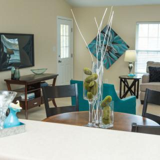 A modern living room with stylish home decor, featuring a table centerpiece and abstract wall art.