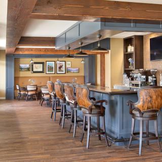 A modern bar interior with wooden flooring and stylish seating.