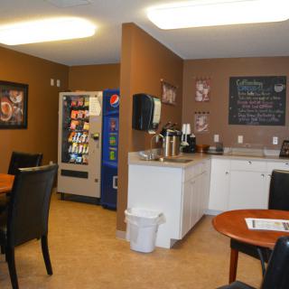 A cozy break room featuring a vending machine, coffee station, and seating area.
