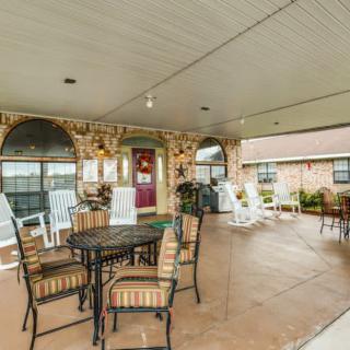 A spacious covered patio with outdoor seating and decorative brick walls.