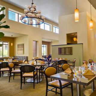 A well-lit restaurant dining area with neatly set tables and elegant decor.