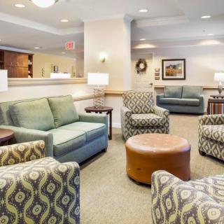 A cozy lounge area with sofas, patterned chairs, and a central coffee table.