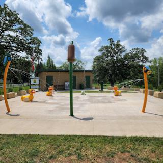 A vibrant outdoor playground featuring water play features, perfect for children to enjoy on a sunny day.