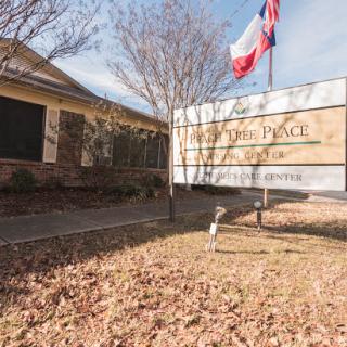 A community center in Texas, adorned with the state flag, surrounded by fallen leaves during autumn.