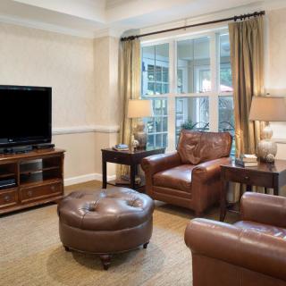 A cozy living room with leather furniture and a large window.