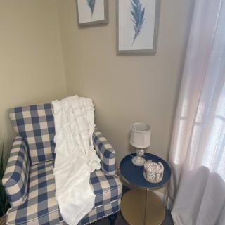 A cozy reading nook with a plaid armchair and a side table adorned with decor.