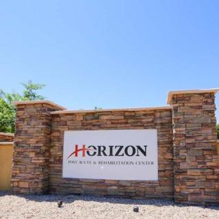 A stone sign displaying 'Horizon', set against a clear blue sky.