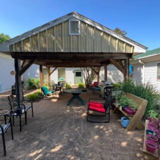 A cozy backyard patio with a wooden gazebo and comfortable seating.