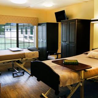A hospital room with two beds and a view of the outdoors.