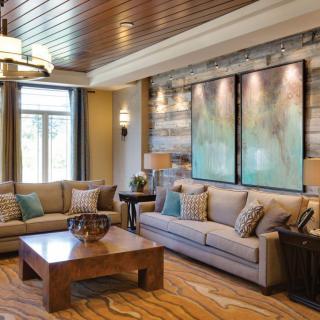 A cozy living room with comfortable sofas, a wooden coffee table, and large artworks on the wall.
