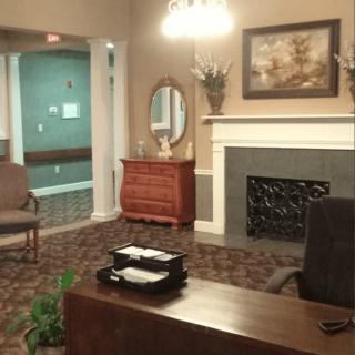 A cozy office interior with a desk, fireplace, and decorative elements.