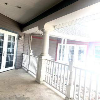 A bright and inviting porch area featuring elegant columns and a view of the outdoors.