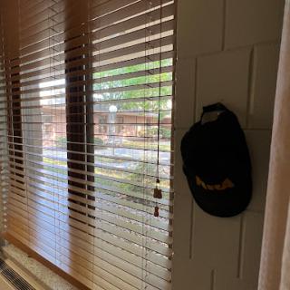 A cozy interior scene featuring window blinds and a hat hanging nearby.