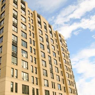 A modern apartment building under a partly cloudy sky.