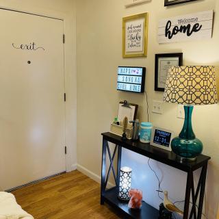 A cozy entryway with decorative wall art, a table lamp, and welcoming home decor.