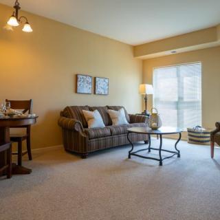 A cozy living room with a sofa, coffee table, and a window bringing in natural light.