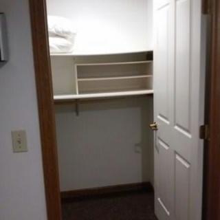 An empty closet with shelves and an open door.